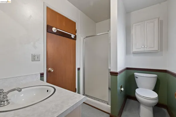 a bathroom with a granite countertop toilet sink and mirror