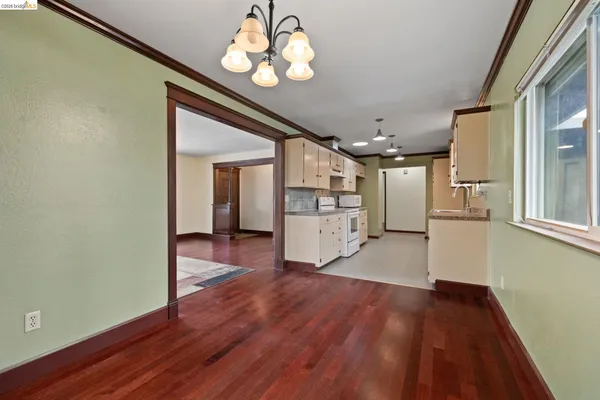a view of a hallway with wooden floor and chandelier