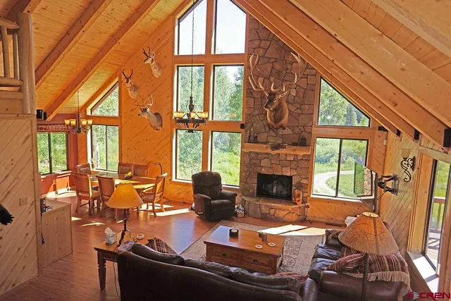 a living room with furniture a fireplace and floor to ceiling windows