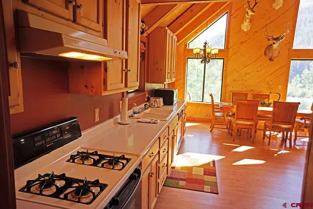a kitchen with stainless steel appliances granite countertop a stove a sink dishwasher and cabinets with wooden floor