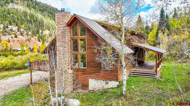 a view of house with a small yard and wooden fence
