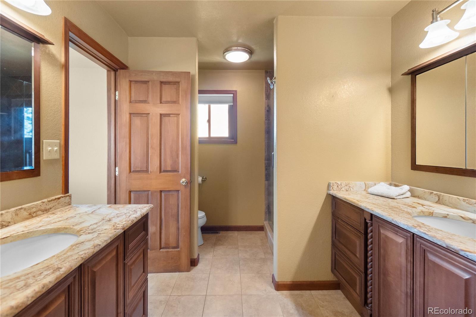 74 Rocky Cliff Road Elizabeth, CO 80107 - Photo 25 of 50 a bathroom with a granite countertop sink and a mirror