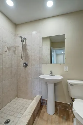 a bathroom with a sink a toilet and shower