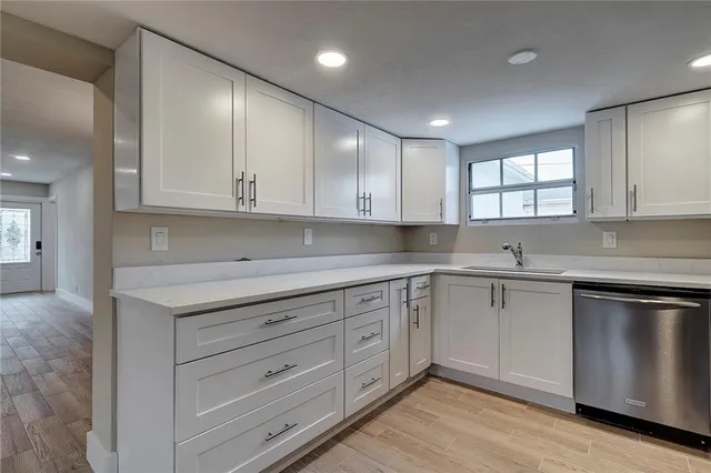a kitchen with granite countertop cabinets stainless steel appliances a sink and a window