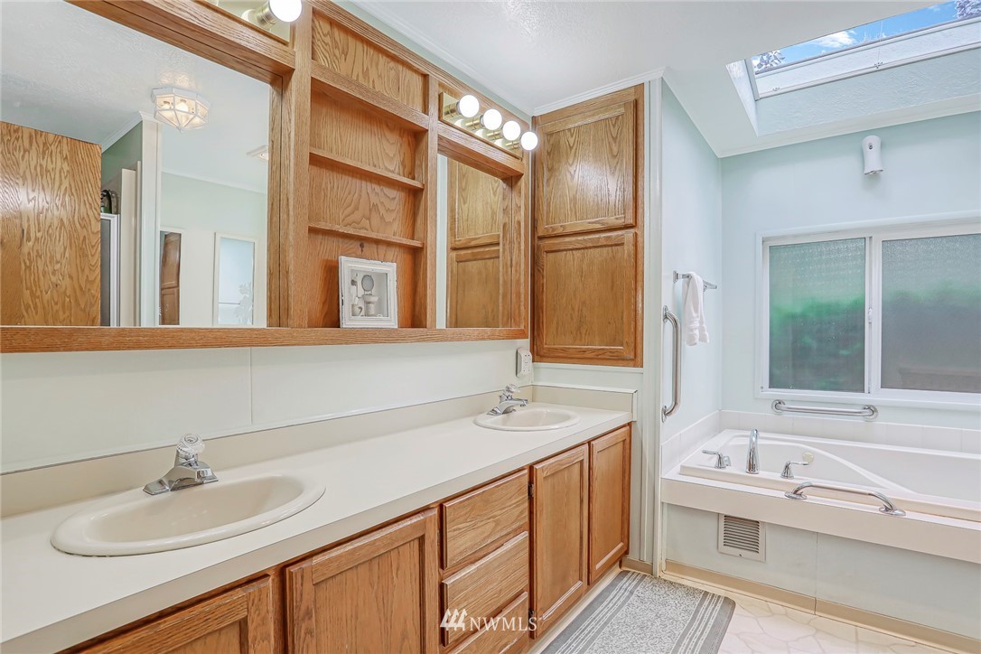 930 243rd Street Southwest Bothell, WA 98021 - Photo 19 of 37 a bathroom with a granite countertop sink and a mirror