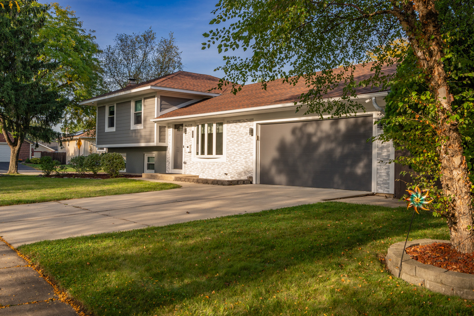 909 Springfield Drive Roselle, IL 60172 - Photo 3 of 42 a view of a white house with a big yard and large trees