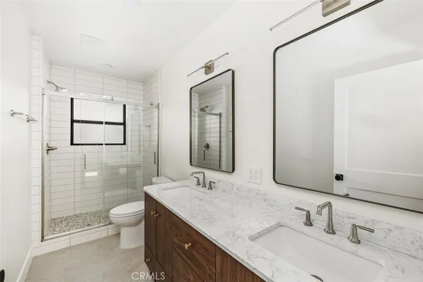 a bathroom with a granite countertop sink a toilet and shower