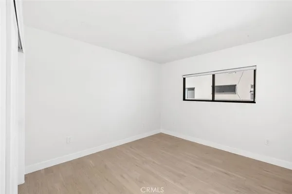 a view of a small space with wooden floor and a window