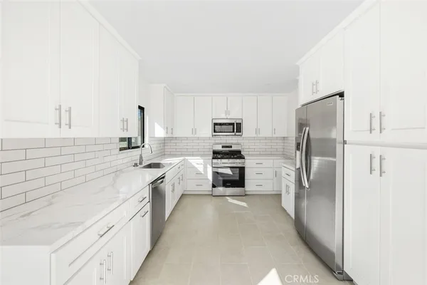 a large kitchen with cabinets stainless steel appliances and a counter space