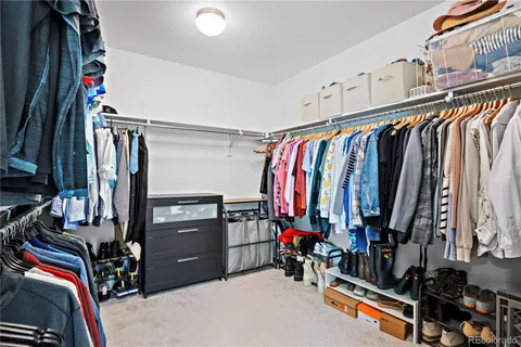 a view of walk in closet with clothes and shoes