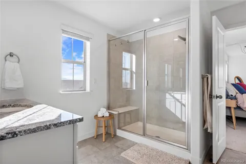 a bathroom with a granite countertop sink a mirror and shower