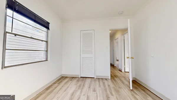 a view of a room with wooden floor and a window