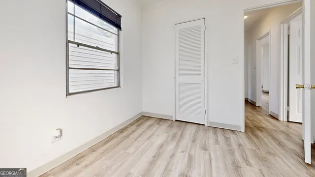 a view of a room with wooden floor and a window