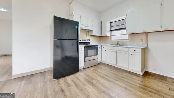 a kitchen with a refrigerator sink and cabinets