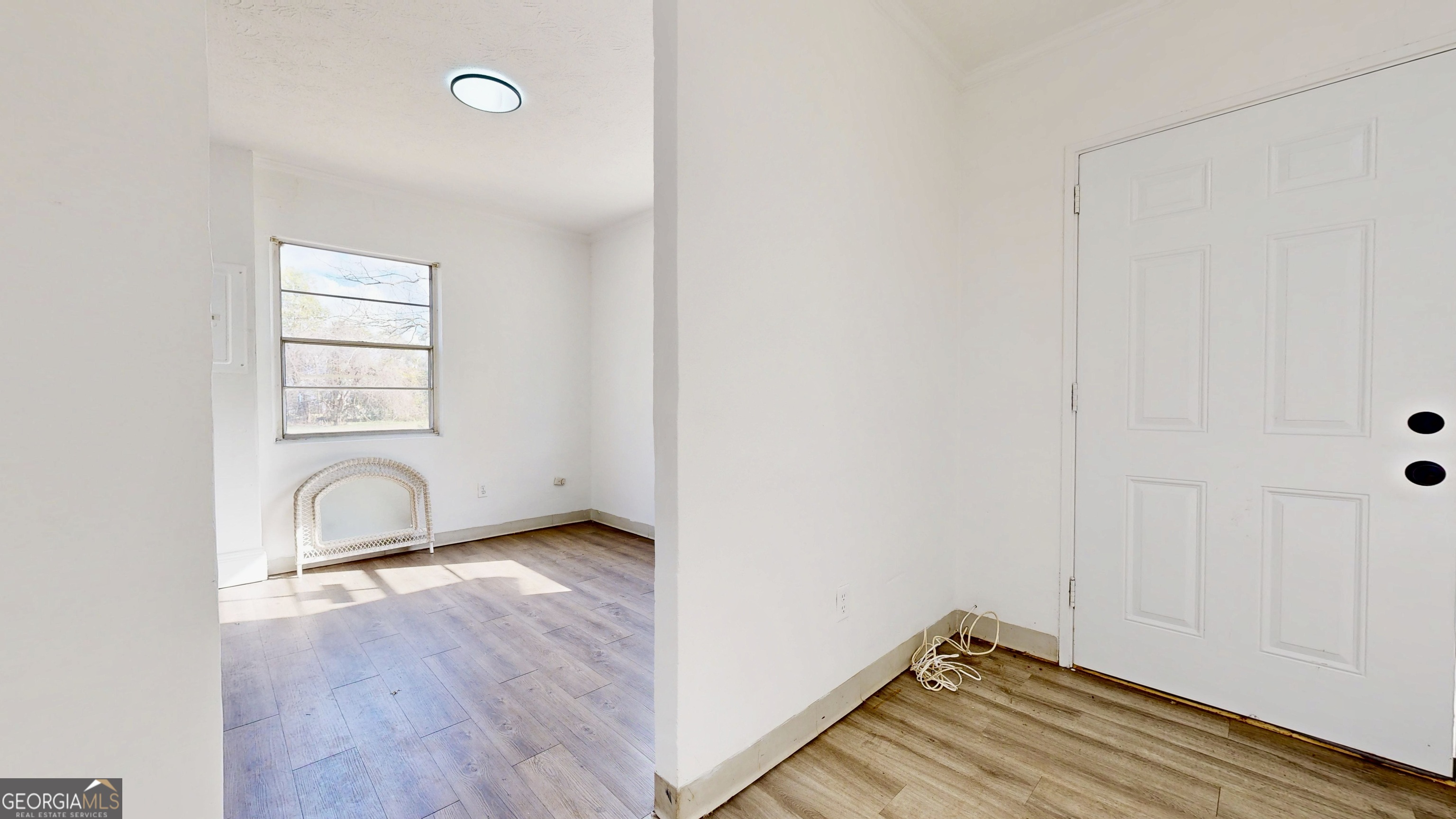 526 Ware Street Blackshear, GA 31516 - Photo 4 of 26 an empty room with wooden floor and windows