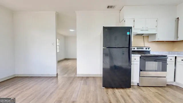 a kitchen with a refrigerator and a stove top oven