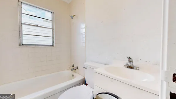 a bathroom with a bathtub shower sink vanity and a toilet