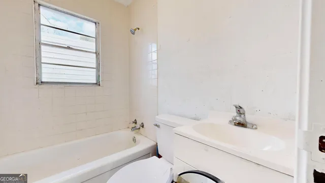 a bathroom with a bathtub shower sink vanity and a toilet