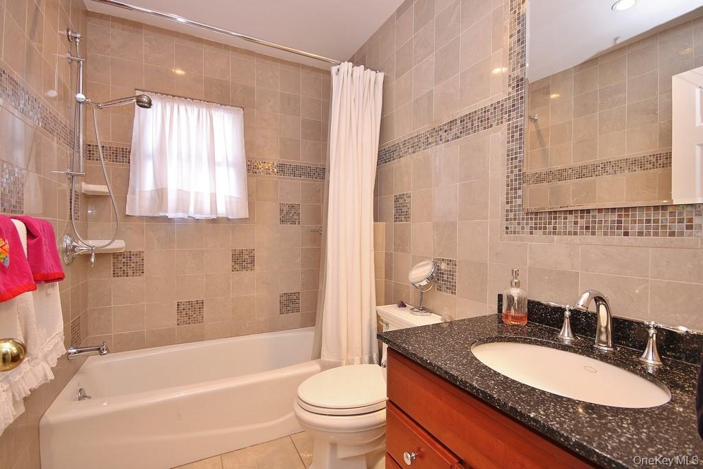 2597 Quaker Church Road Yorktown Heights, NY 10598 - Photo 16 of 37 a bathroom with a granite countertop sink toilet mirror and bathtub