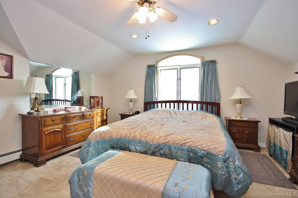 2597 Quaker Church Road Yorktown Heights, NY 10598 - Photo 18 of 37 a spacious bedroom with a large bed and a chandelier