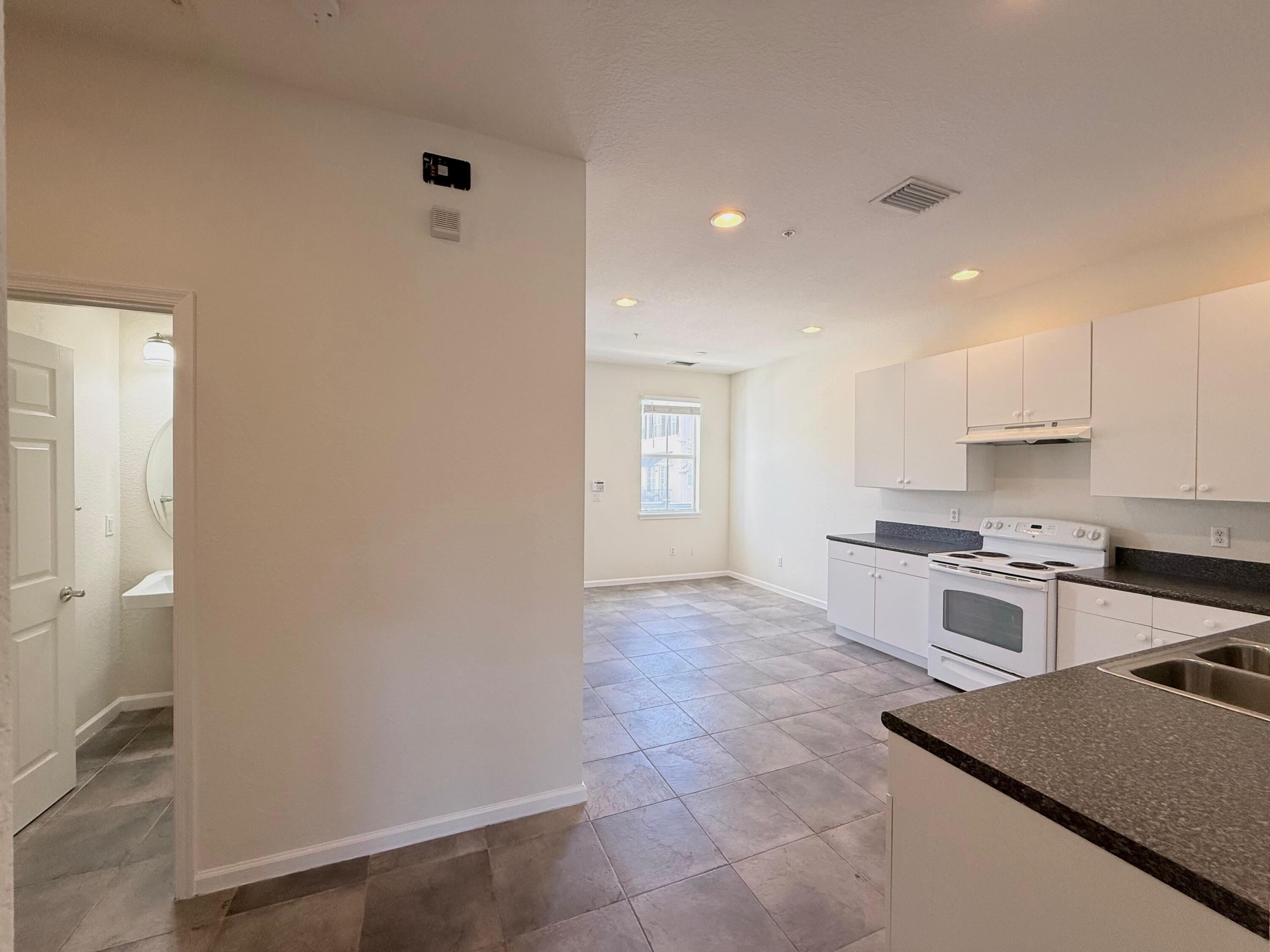 425 Greenwich Circle, Unit 206 Jupiter, FL 33458 - Photo 12 of 30 a kitchen with stainless steel appliances granite countertop a stove a sink and a refrigerator