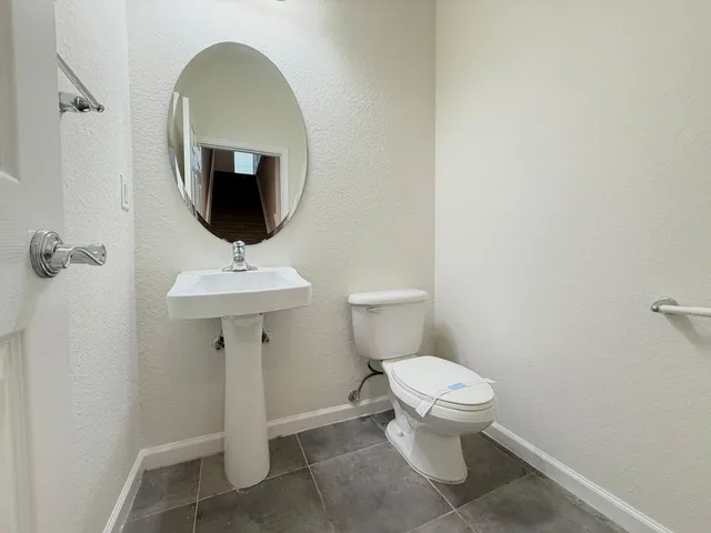 a bathroom with a toilet sink and mirror