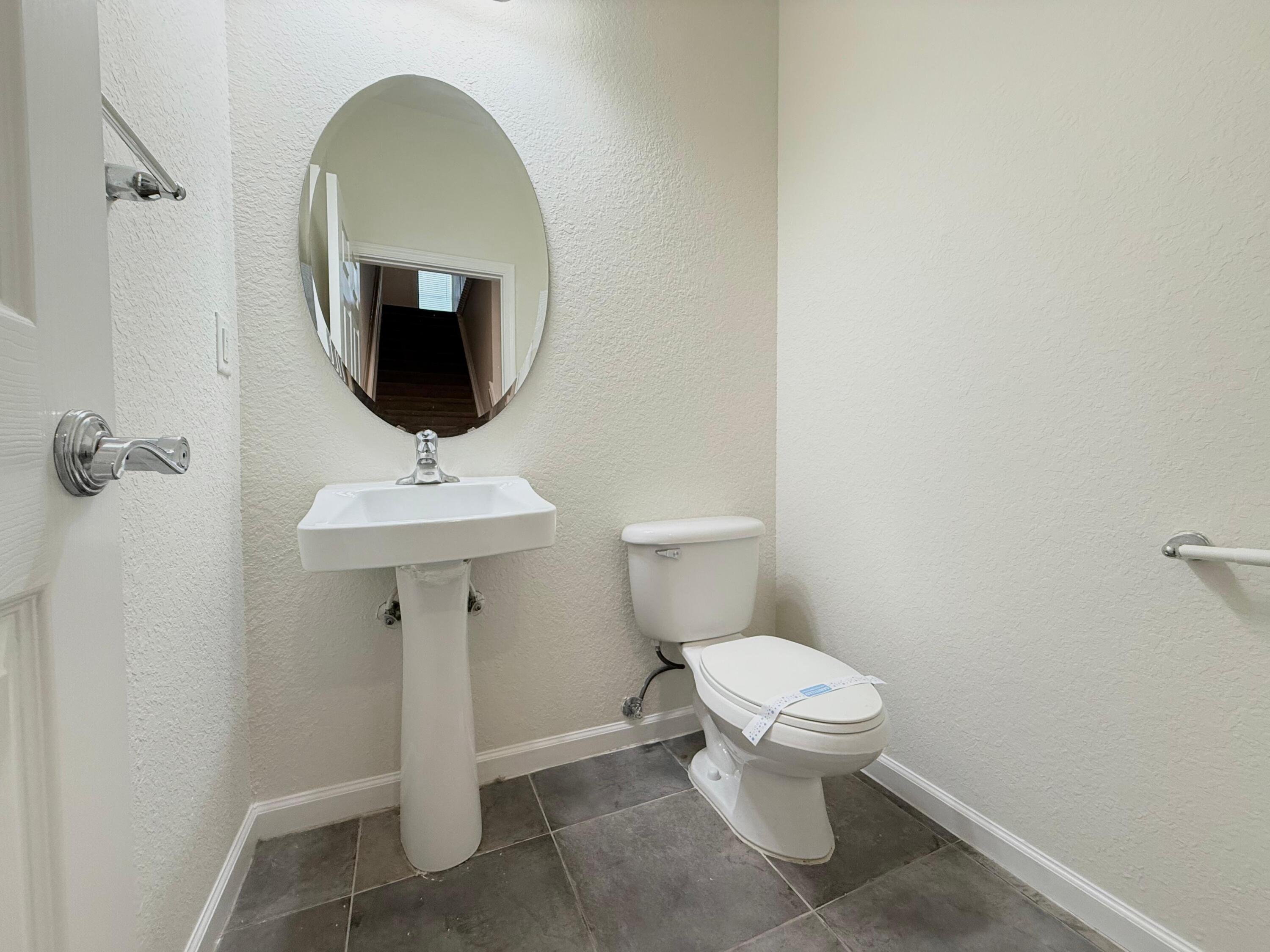 425 Greenwich Circle, Unit 206 Jupiter, FL 33458 - Photo 14 of 30 a bathroom with a toilet sink and mirror