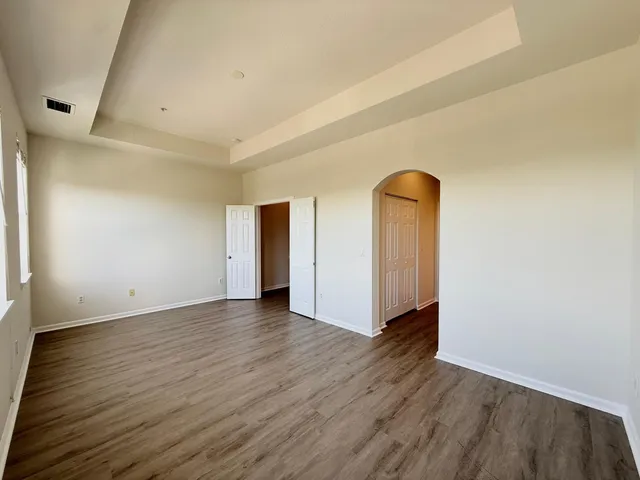 a view of an empty room with wooden floor