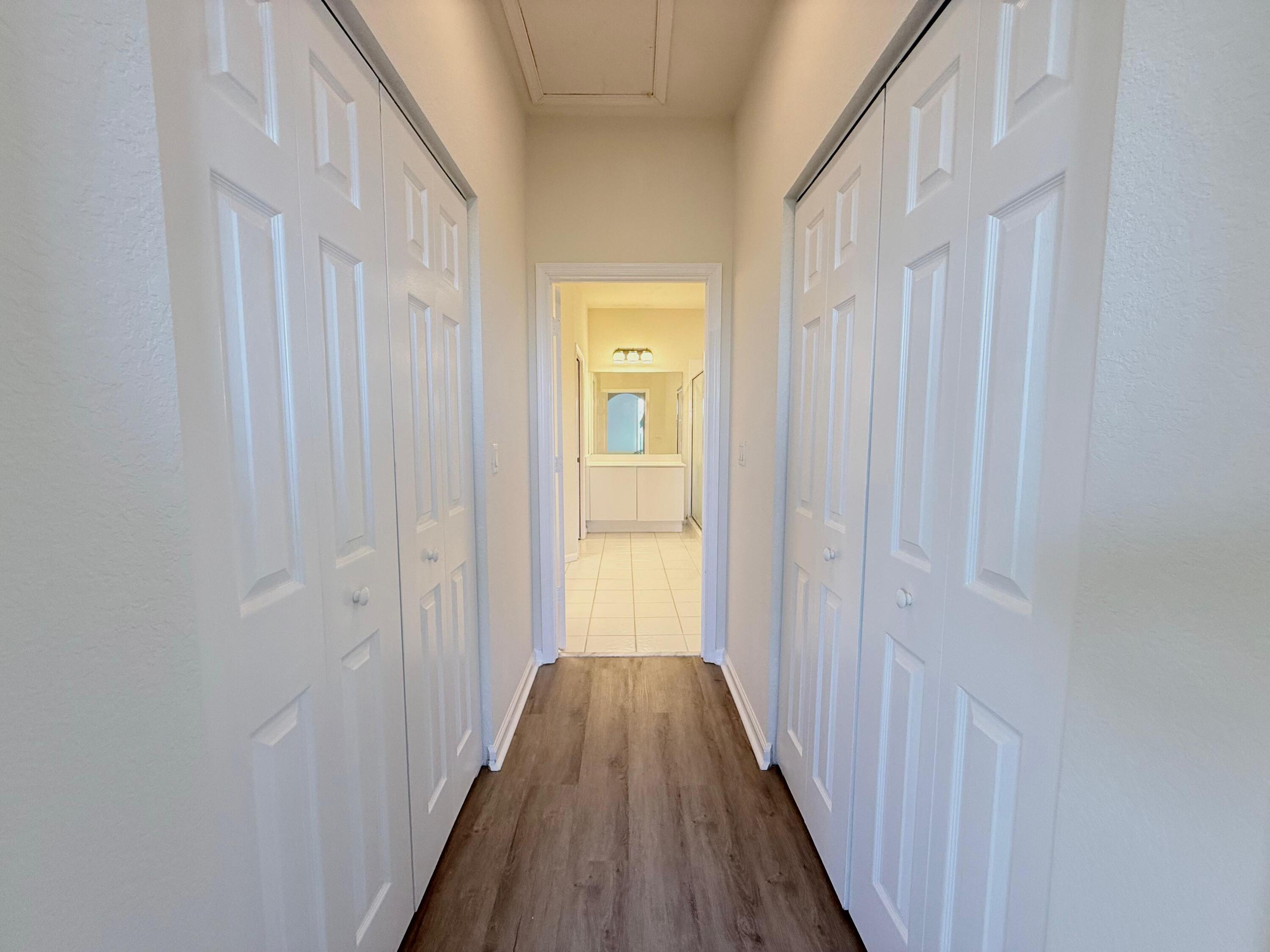 425 Greenwich Circle, Unit 206 Jupiter, FL 33458 - Photo 21 of 30 a view of a hallway with wooden floor and a bathroom