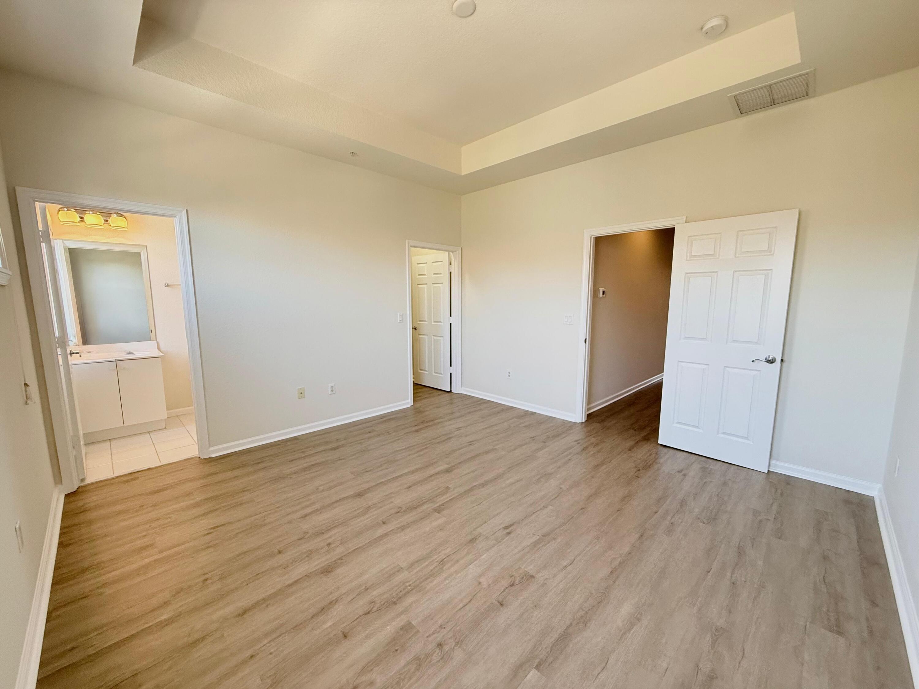 425 Greenwich Circle, Unit 206 Jupiter, FL 33458 - Photo 25 of 30 an empty room with wooden floor and mirror