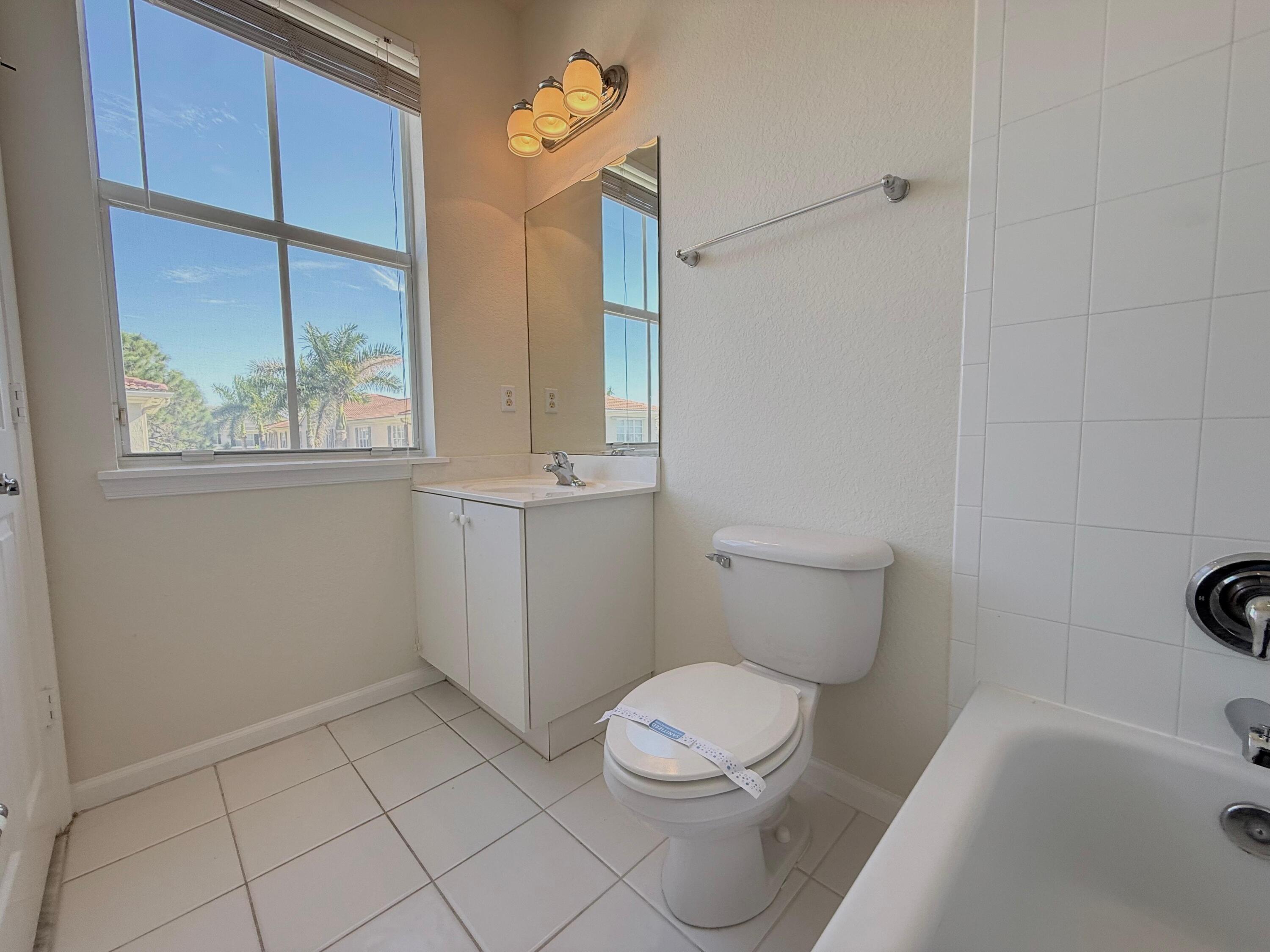 425 Greenwich Circle, Unit 206 Jupiter, FL 33458 - Photo 29 of 30 a white toilet sitting next to a bath tub