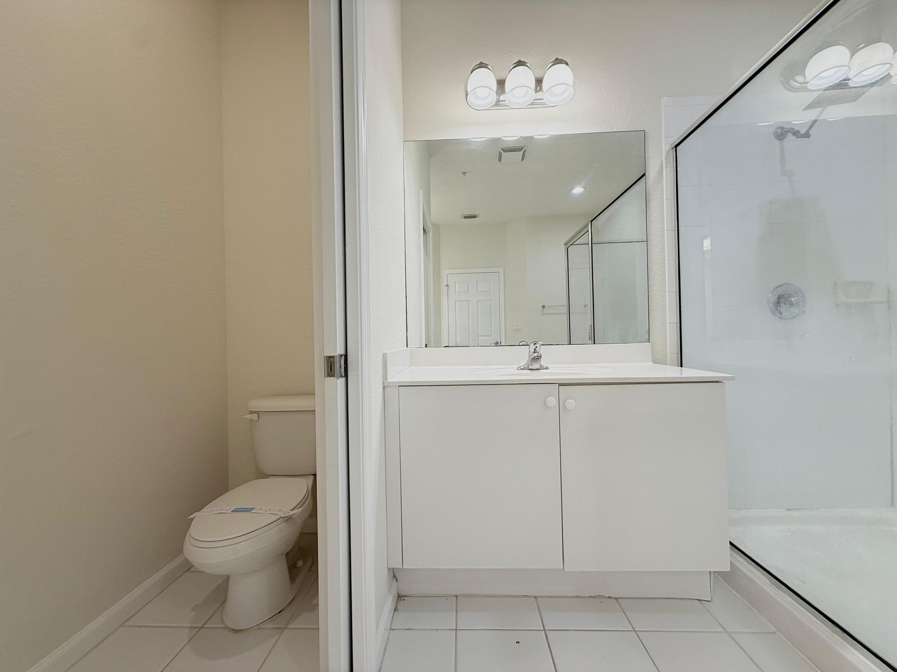 425 Greenwich Circle, Unit 206 Jupiter, FL 33458 - Photo 30 of 30 a bathroom with a toilet sink and mirror