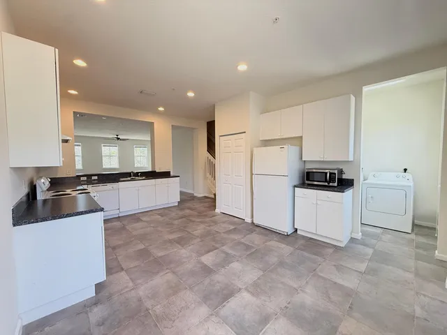 a large white kitchen with stainless steel appliances