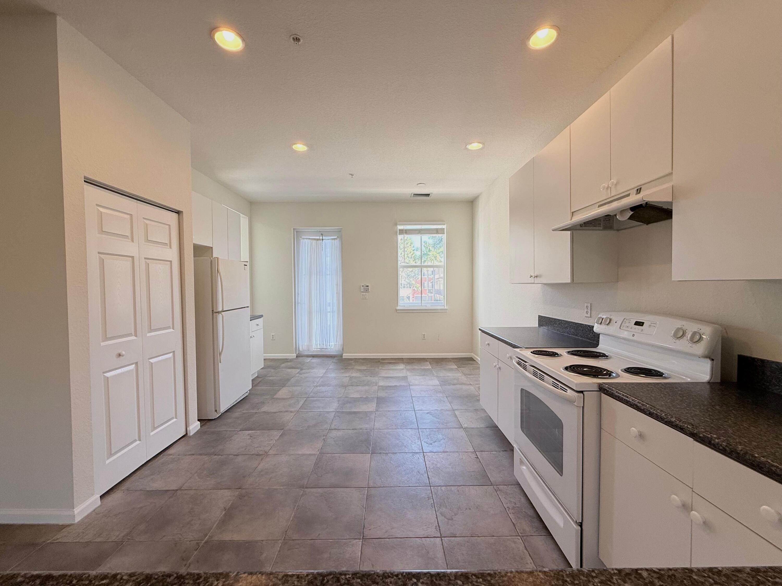 425 Greenwich Circle, Unit 206 Jupiter, FL 33458 - Photo 4 of 30 a kitchen with stainless steel appliances granite countertop a stove a sink and a refrigerator