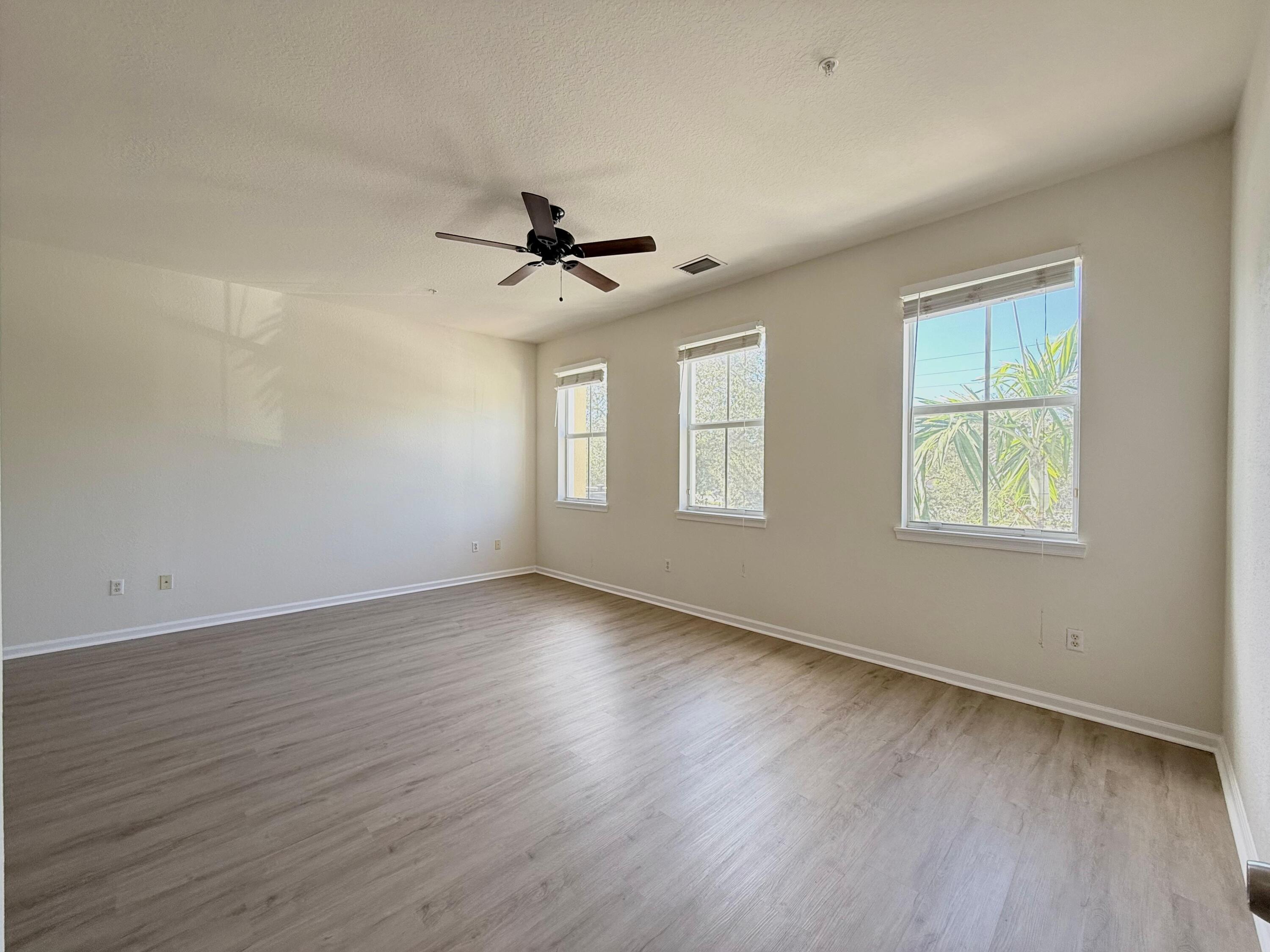 425 Greenwich Circle, Unit 206 Jupiter, FL 33458 - Photo 8 of 30 a view of an empty room with wooden floor and a window