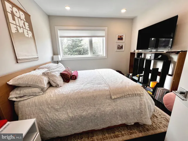 a bedroom with a bed and flat screen tv
