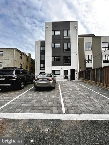 a front view of a building with glass windows and fence
