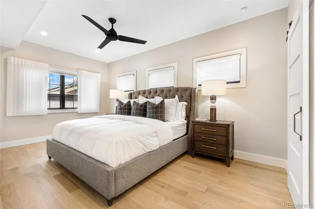 a bed room with a bed and a ceiling fan