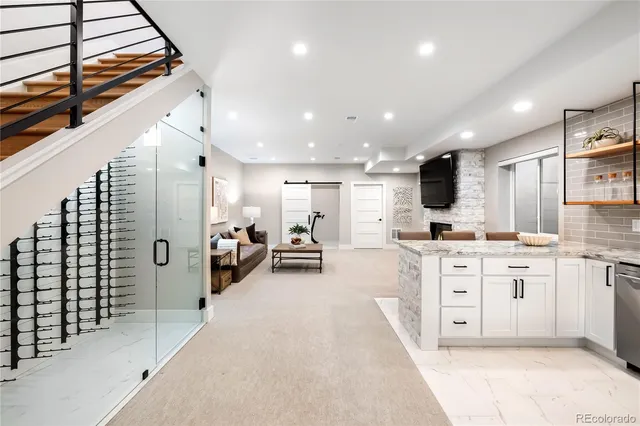 a large white kitchen with stainless steel appliances lots of white cabinets