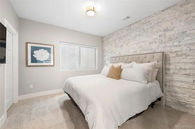 a bedroom with bed and painting on the wall