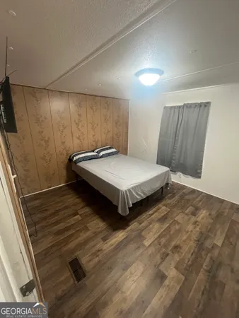 a bedroom with a bed and wooden floor