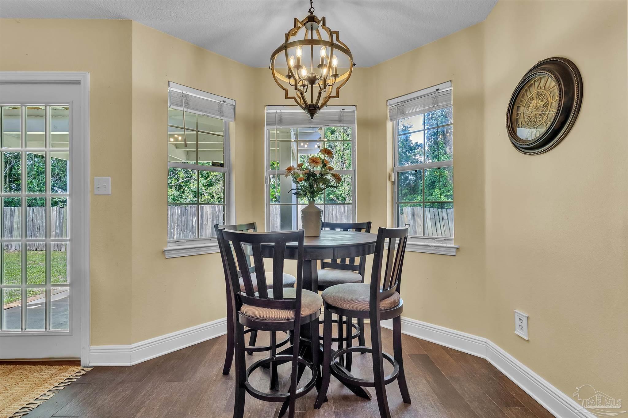 4321 Ridgeland Drive Pace, FL 32571 - Photo 6 of 36 a view of a dining room with furniture a chandelier and wooden floor