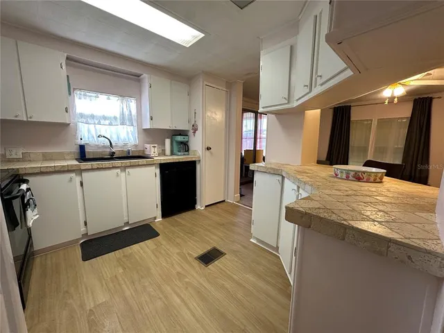 a kitchen with stainless steel appliances granite countertop a sink a stove and cabinets