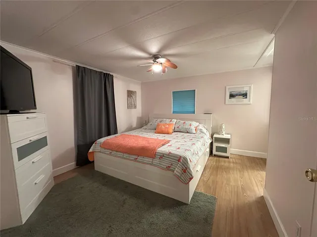 a bedroom with a bed and a flat tv screen on dresser