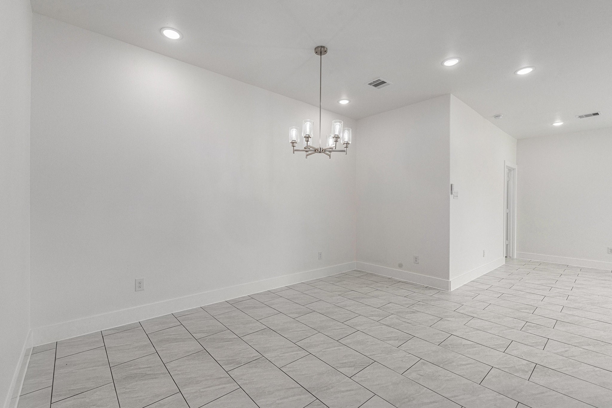 702 Azalea Street Waller, TX 77484 - Photo 17 of 45 an empty room with kitchen and chandelier fan