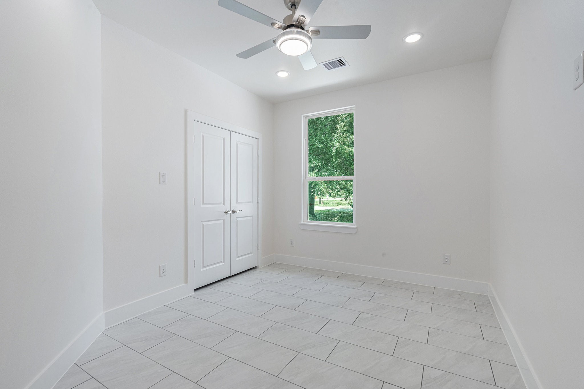 702 Azalea Street Waller, TX 77484 - Photo 21 of 45 an empty room with windows and fan