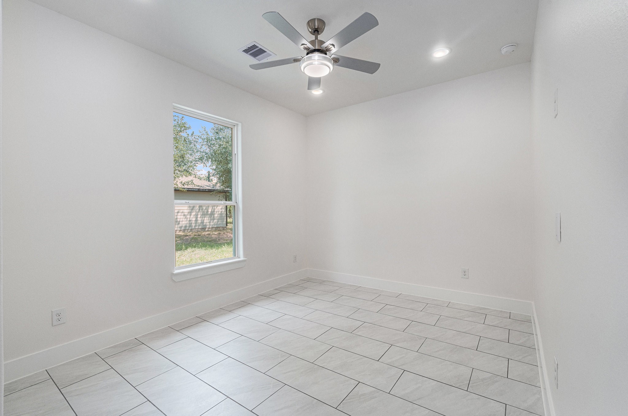 702 Azalea Street Waller, TX 77484 - Photo 40 of 45 an empty room with windows and ceiling fan