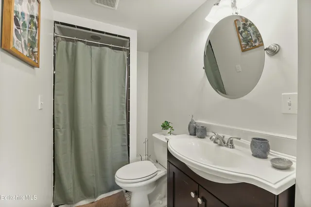a bathroom with a sink toilet and a mirror