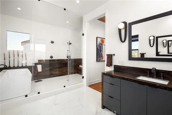 a bathroom with a tub sink and mirror