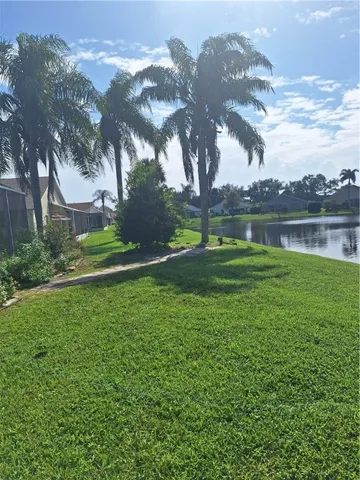 a backyard of a house with lots of green space and lake view